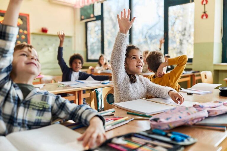 KIds in classroom raising hands