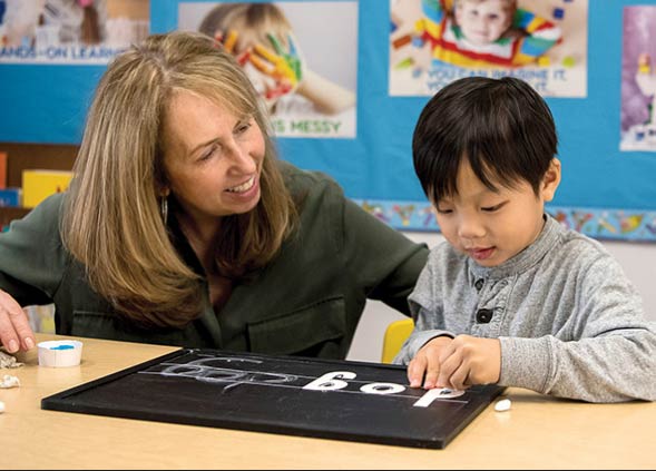 Teacher with child using interactive chalkboard